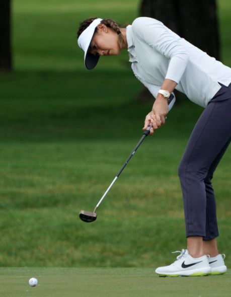 fall golf outfit for women with navy capri pants and a long sleeve collared shirt